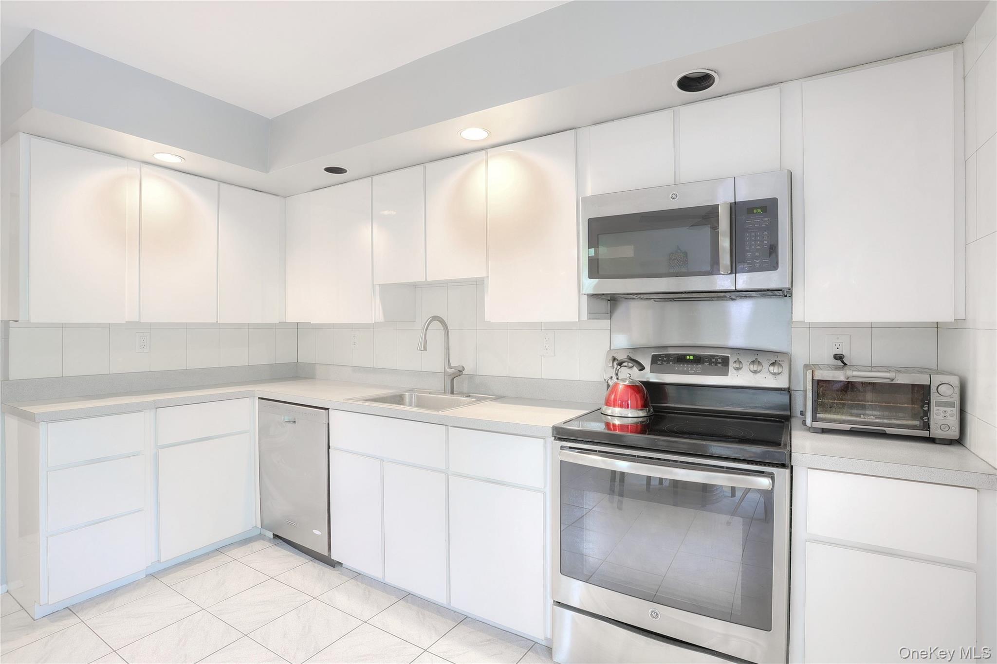 47 Camp Hill Road Pomona, NY 10970 - Photo 13 of 30 a kitchen with stainless steel appliances a stove sink and cabinets