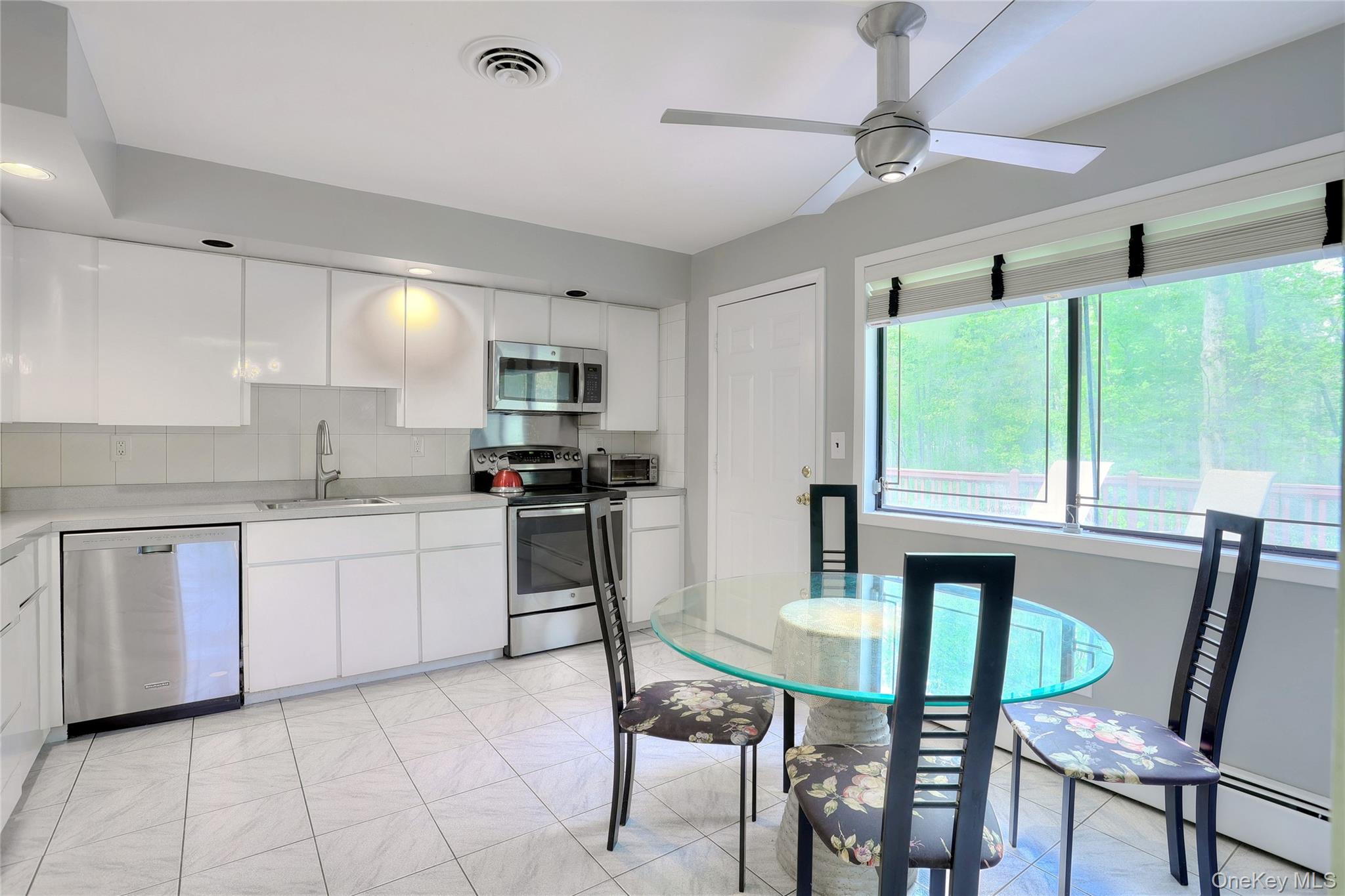 47 Camp Hill Road Pomona, NY 10970 - Photo 10 of 30 a kitchen with granite countertop white cabinets stainless steel appliances dining table and chairs