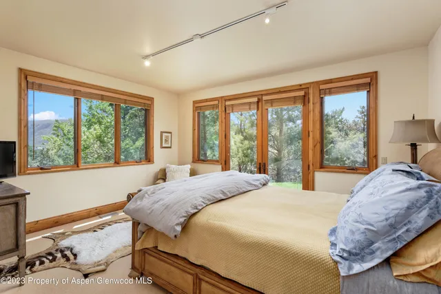 a bedroom with a bed and a large window
