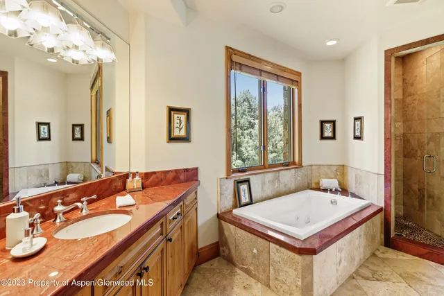 a bathroom with a tub sink and mirror