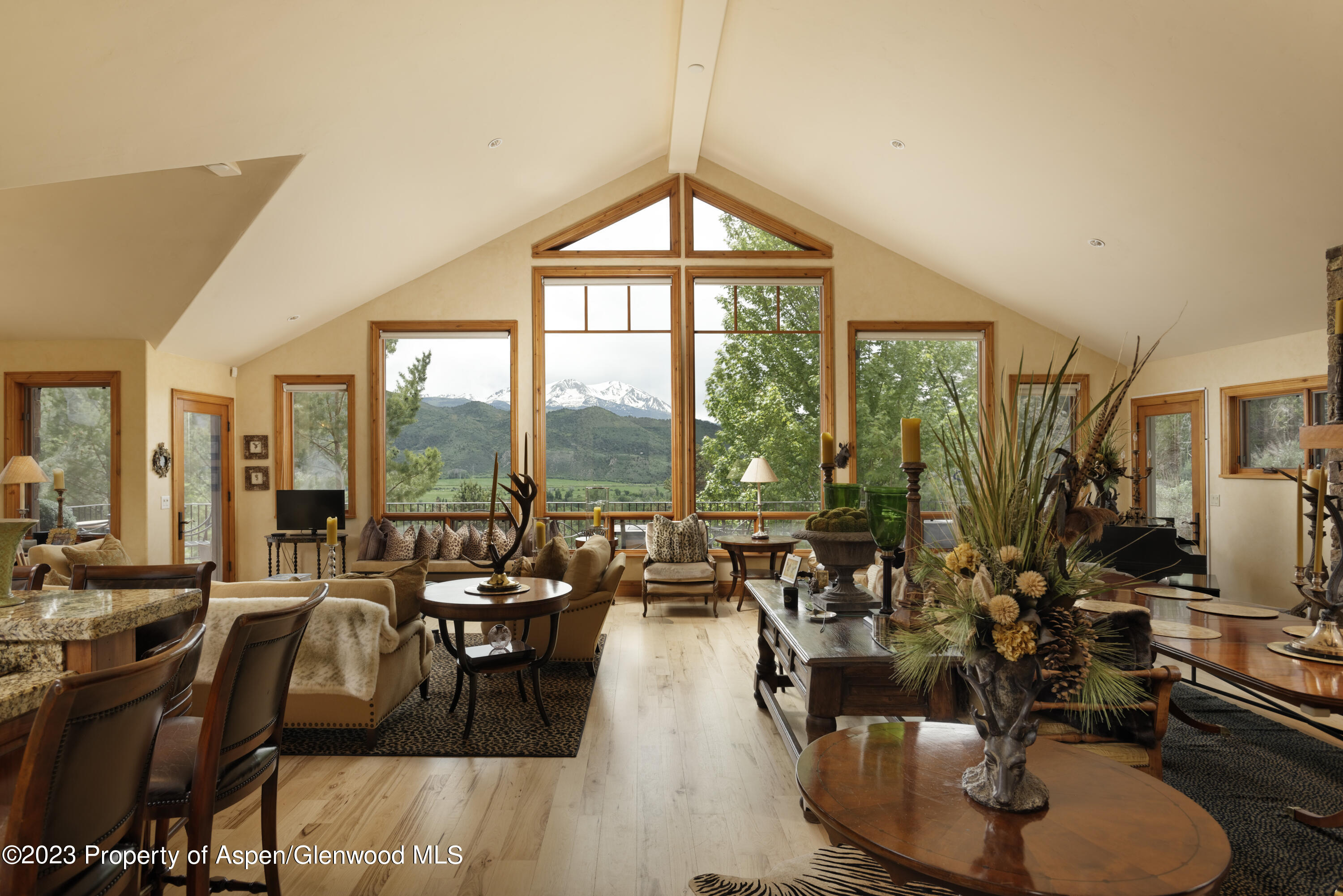 121 Ridge Road Basalt, CO 81621 - Photo 4 of 25 a living room with couches a dining table and chairs with floor to ceiling window