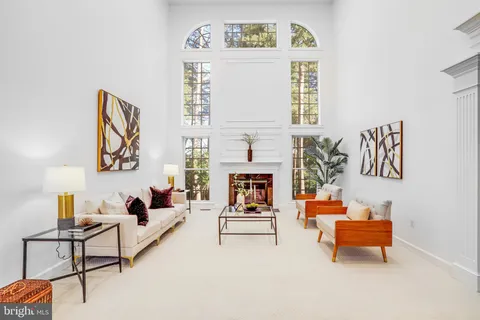 a view of a hallway with a dining table & a chandelier