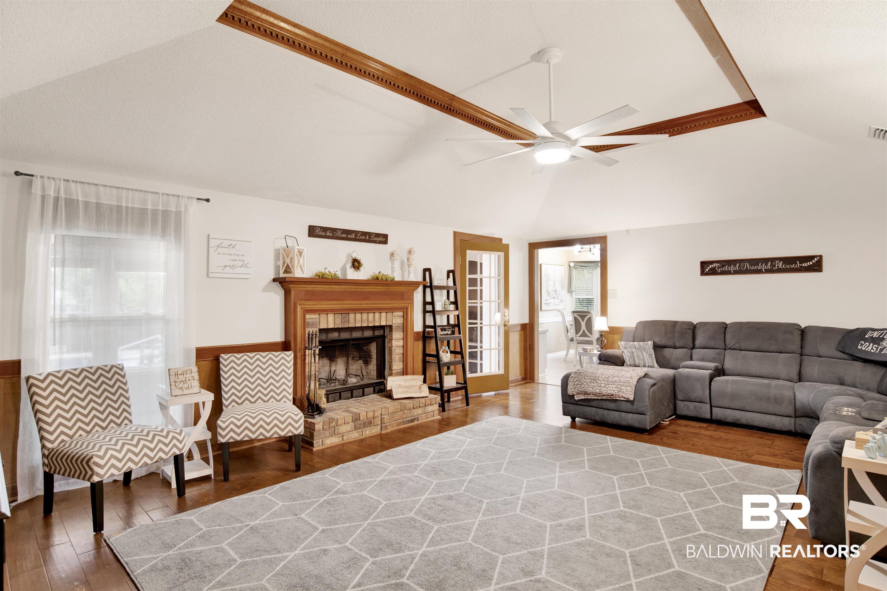 7431 Summer Court Mobile, AL 36695 - Photo 30 of 37 Living area with vaulted ceiling, a ceiling fan, wood finished floors, and a brick fireplace