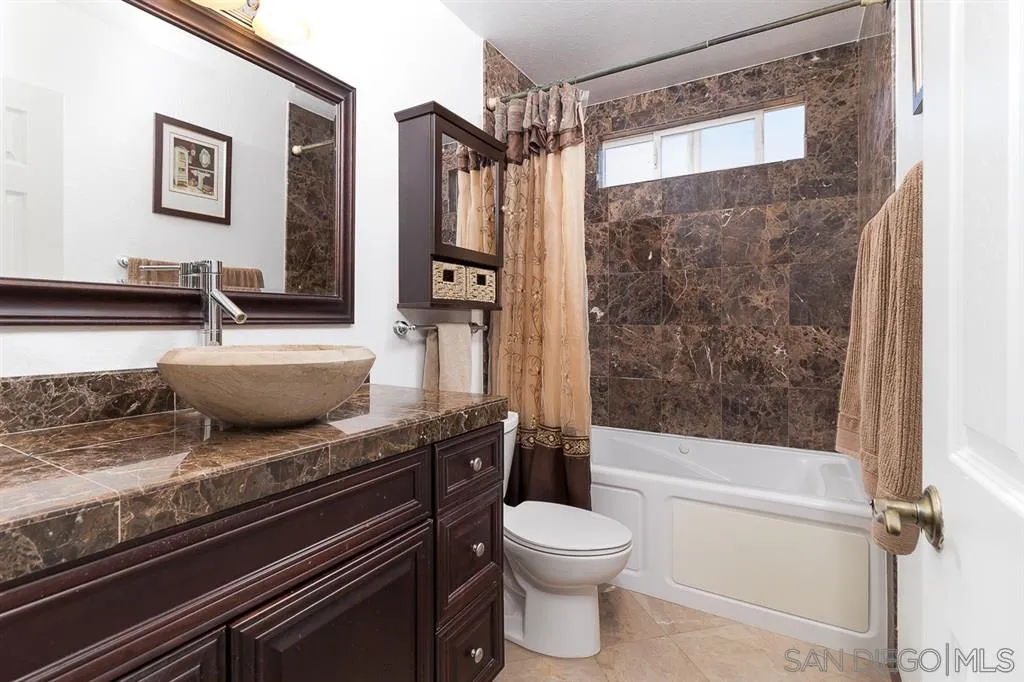 11027 Eddington Road Santee, CA 92071 - Photo 18 of 25 a bathroom with a granite countertop sink a toilet and shower
