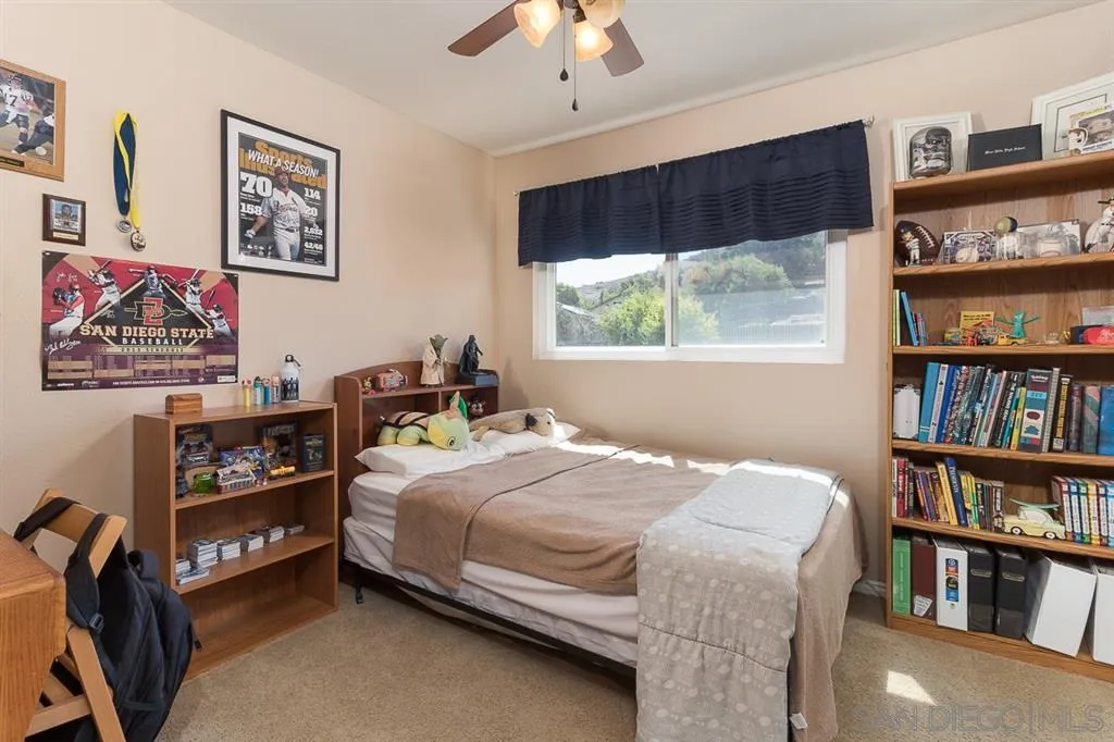 11027 Eddington Road Santee, CA 92071 - Photo 19 of 25 a bedroom with a bed a book shelf and a window