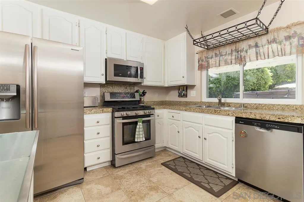 11027 Eddington Road Santee, CA 92071 - Photo 7 of 25 a kitchen with stainless steel appliances a stove sink and refrigerator