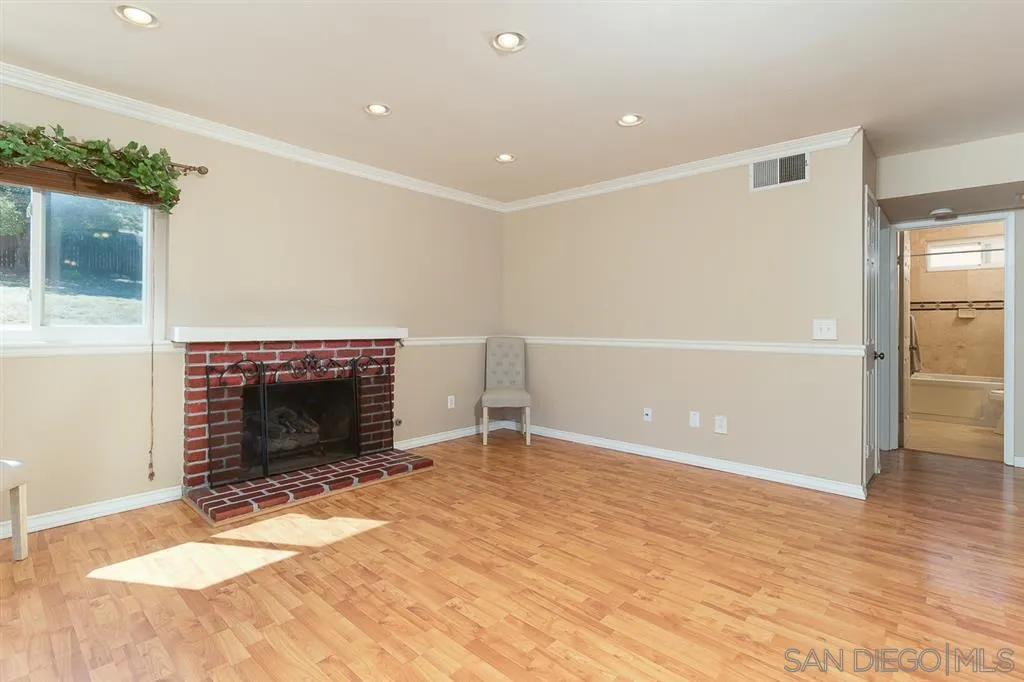 11027 Eddington Road Santee, CA 92071 - Photo 9 of 25 a view of empty room with wooden floor and fireplace