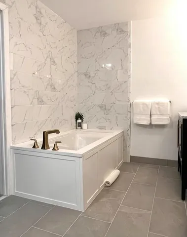 a bedroom with a large bed and a chandelier fan