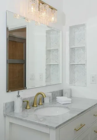 a bathroom with a granite countertop sink and a mirror