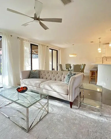 a living room with furniture and a ceiling fan