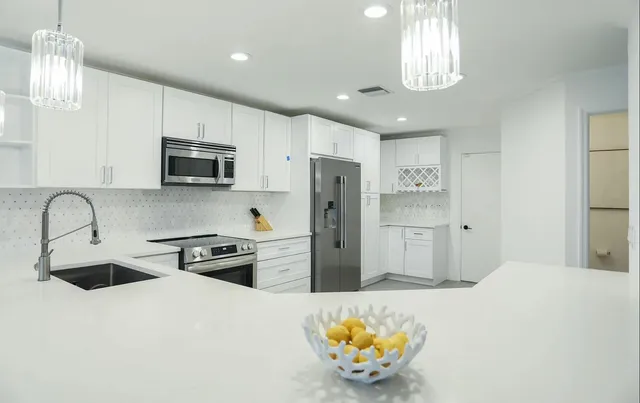 a kitchen with stainless steel appliances a refrigerator sink and stove