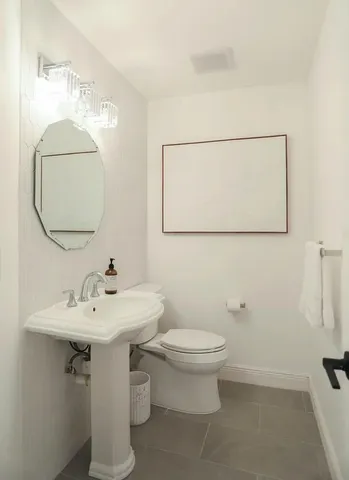 a bathroom with a sink toilet and mirror