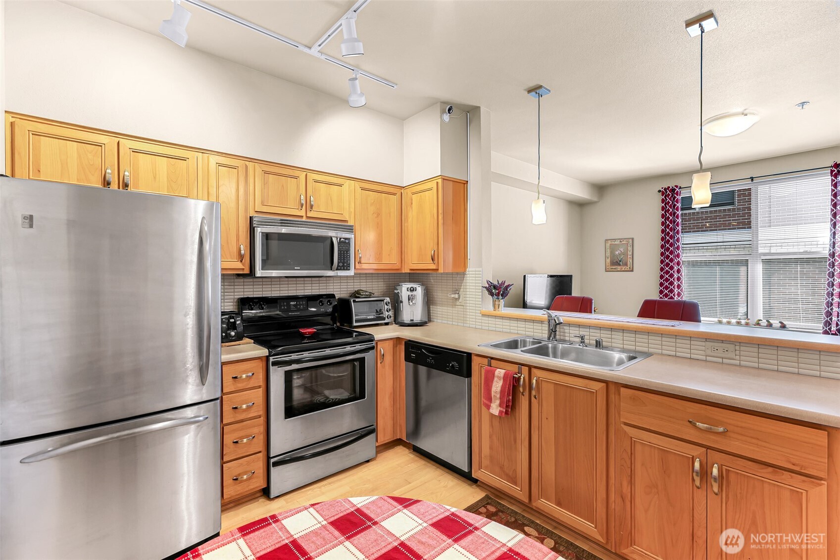 910 Harris Avenue, Unit 208 Bellingham, WA 98225 - Photo 12 of 33 a kitchen with stainless steel appliances granite countertop a refrigerator a sink a stove a microwave and island with wooden floor