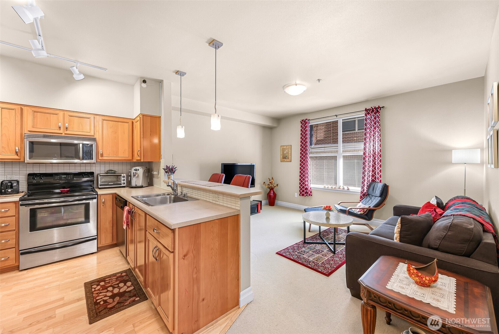 910 Harris Avenue, Unit 208 Bellingham, WA 98225 - Photo 17 of 33 a kitchen with stainless steel appliances granite countertop a stove top oven a sink a dining table and chairs with wooden floor