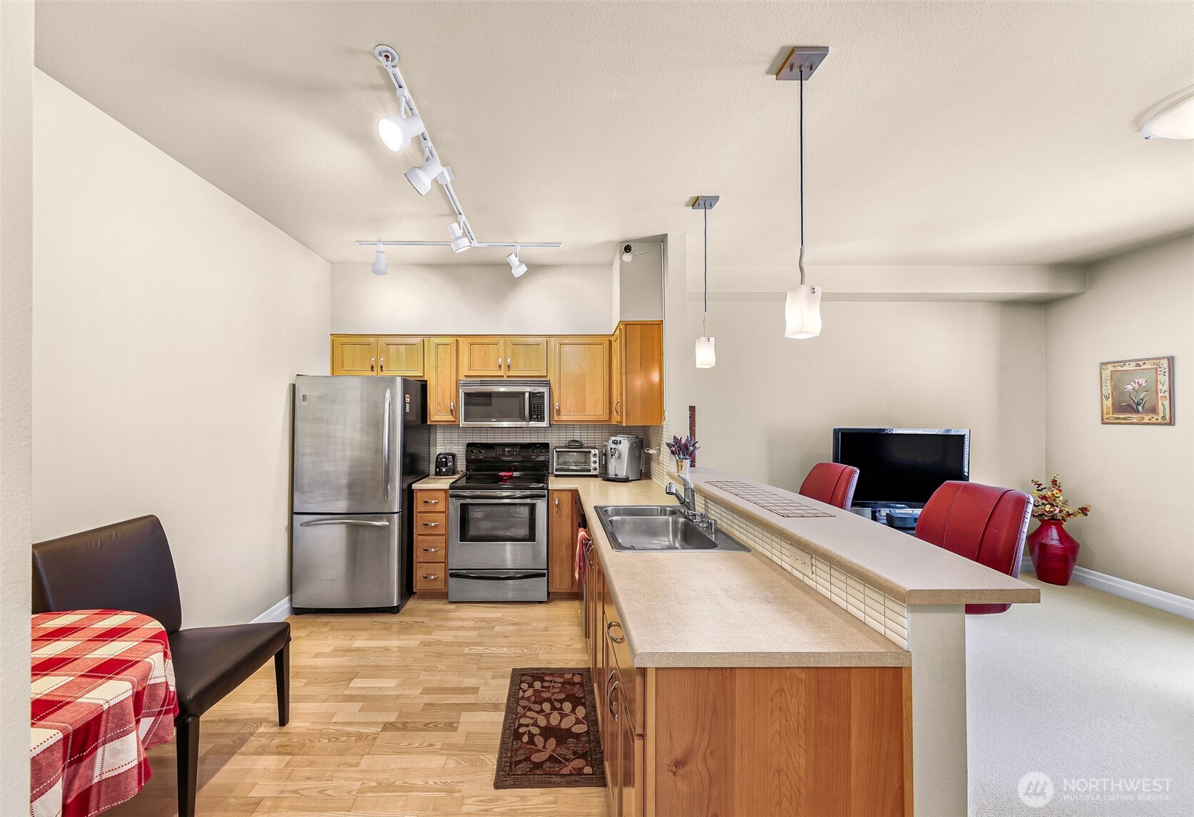 910 Harris Avenue, Unit 208 Bellingham, WA 98225 - Photo 9 of 33 a kitchen with stainless steel appliances kitchen island granite countertop a refrigerator a sink dishwasher a oven with a dining table and chairs with wooden floor