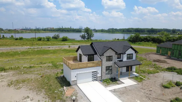 an aerial view of a house with a yard and lake view