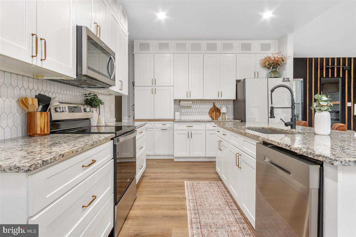 2390 Shirley Road Charles Town, WV 25414 - Photo 12 of 69 a large kitchen with stainless steel appliances granite countertop a sink dishwasher stove and cabinets with wooden floor