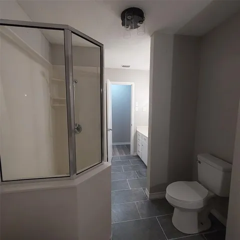 a bathroom with a toilet and a shower