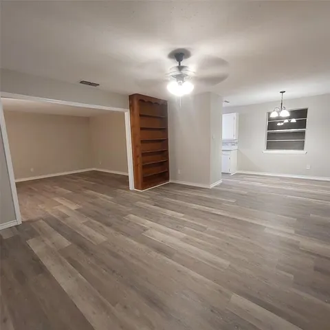 an empty room with windows and fan