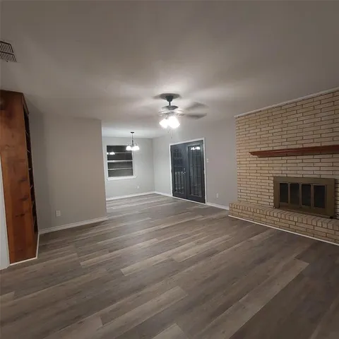 a view of an empty room with a fireplace and a window