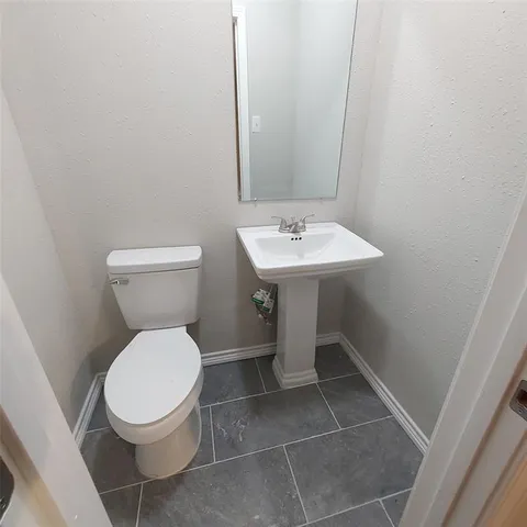a bathroom with a toilet a sink and a mirror