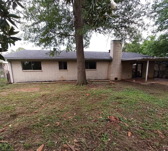 a view of house with backyard and tree