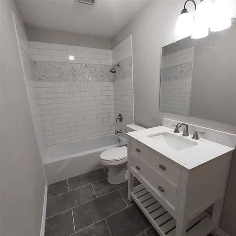 a bathroom with a double vanity sink toilet and shower