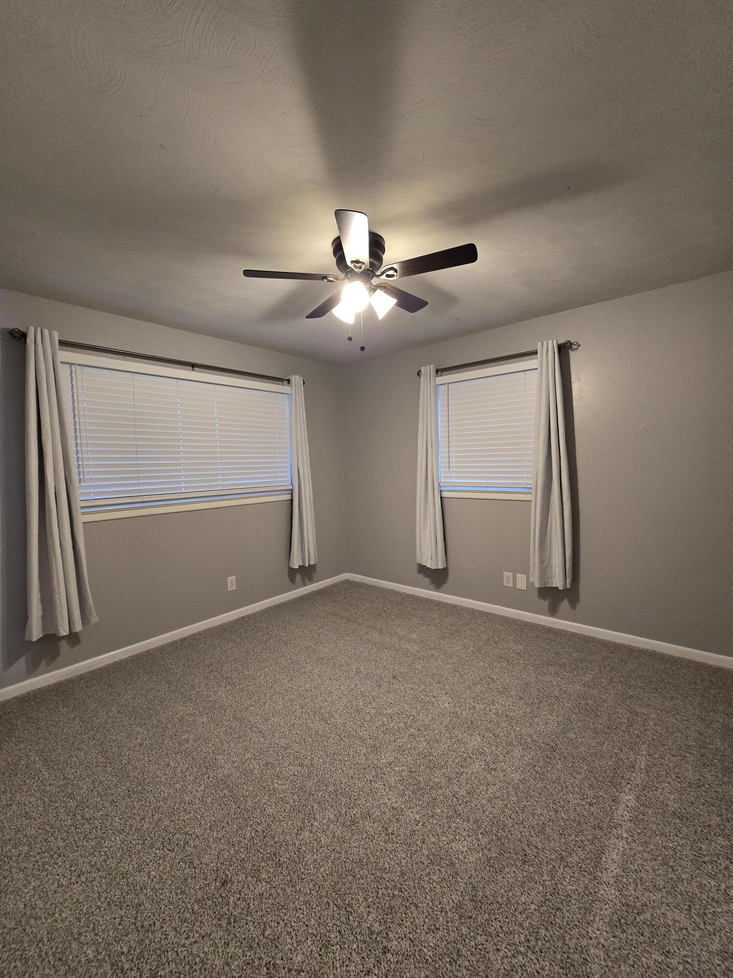 305 North 21st Street Lamesa, TX 79331 - Photo 13 of 23 a view of an empty room with a ceiling fan and window
