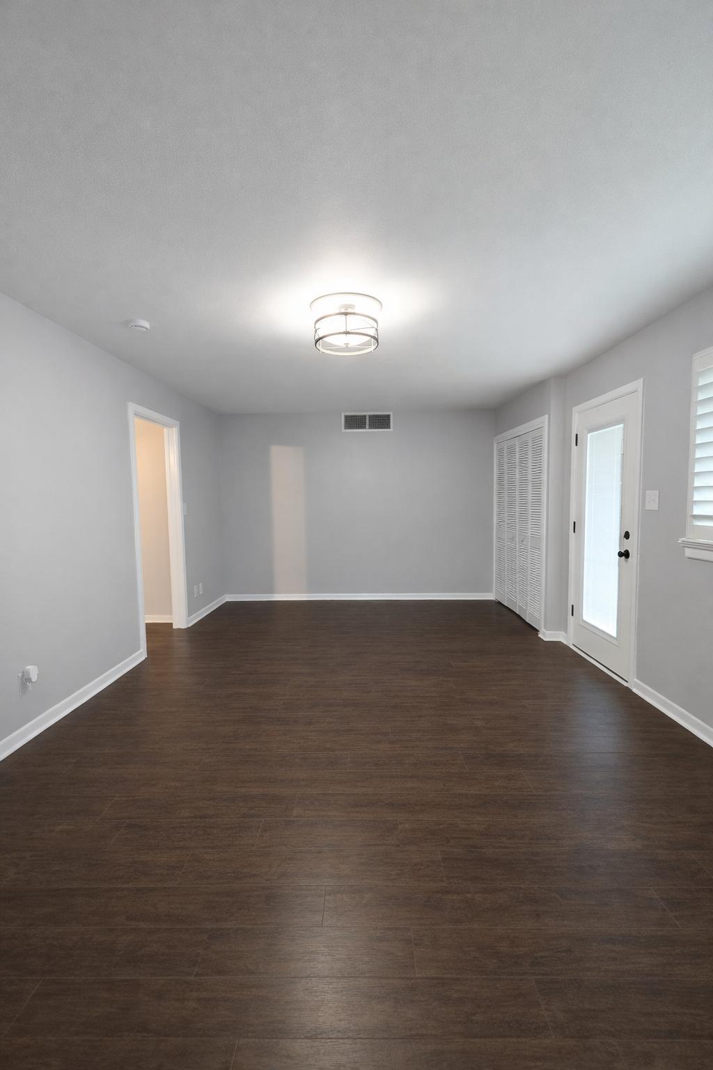 305 North 21st Street Lamesa, TX 79331 - Photo 2 of 23 an empty room with wooden floor and windows