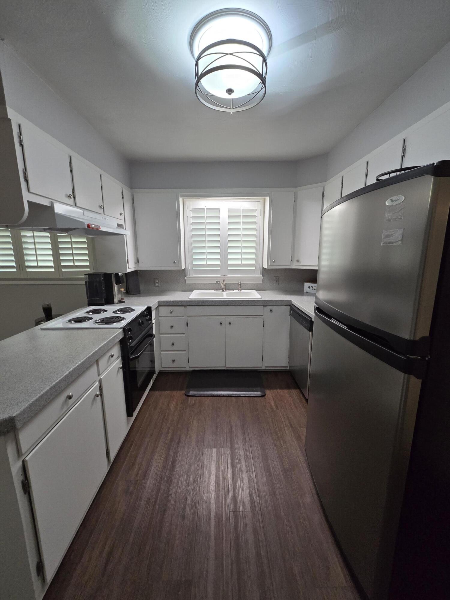 305 North 21st Street Lamesa, TX 79331 - Photo 3 of 23 a kitchen with cabinets wooden floor and stainless steel appliances