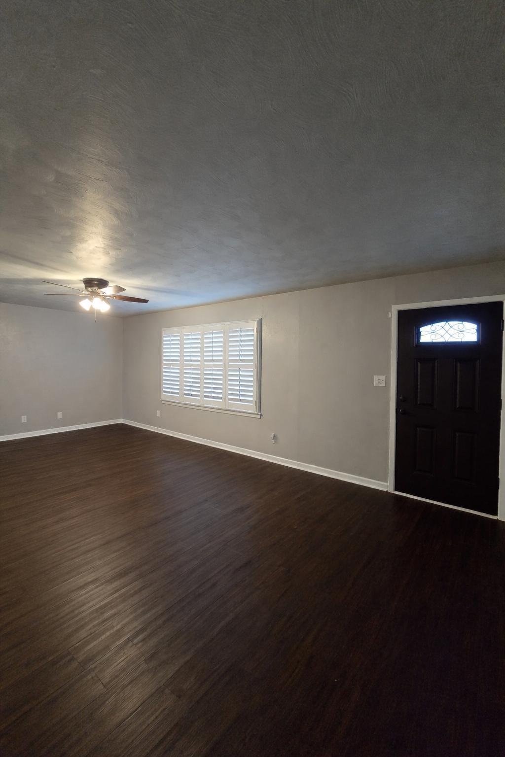 305 North 21st Street Lamesa, TX 79331 - Photo 5 of 23 an empty room with wooden floor and windows