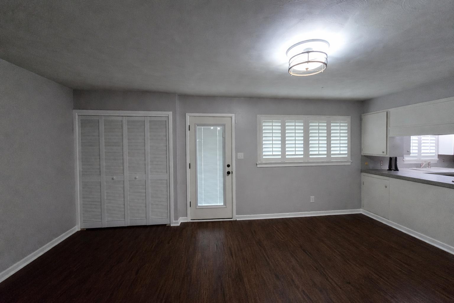 305 North 21st Street Lamesa, TX 79331 - Photo 7 of 23 an empty room with wooden floor and windows