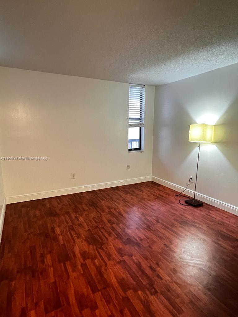 6800 Cypress Road, Unit 211 Plantation, FL 33317 - Photo 10 of 19 a view of an empty room with window and wooden floor