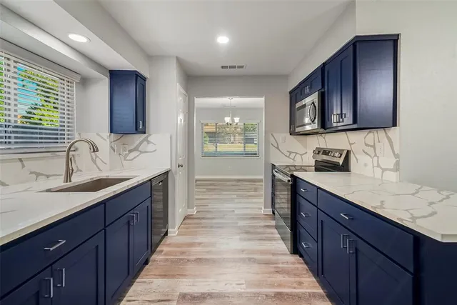 a large kitchen with wooden cabinets and a sink