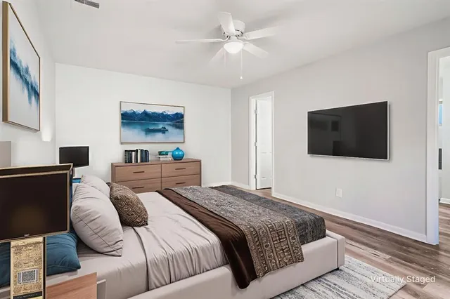 a bedroom with a bed a couch and a flat screen tv