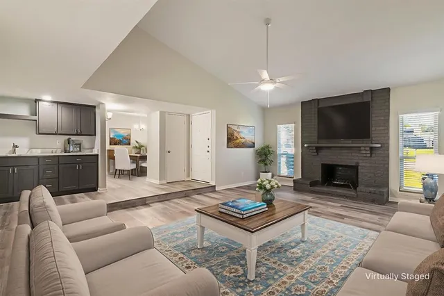 a living room with furniture a fireplace and a flat screen tv