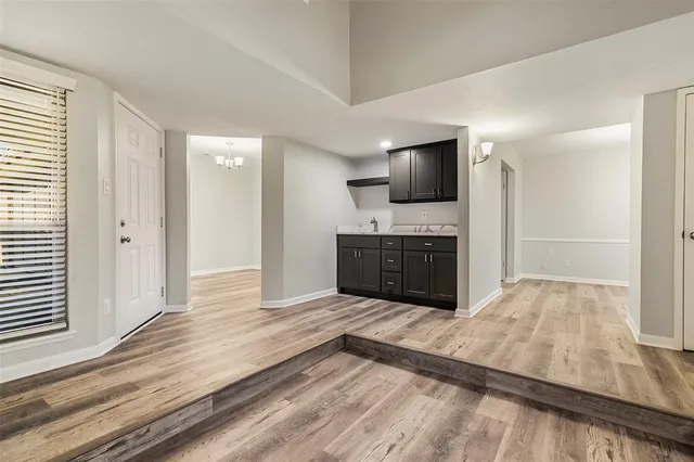 a room with kitchen island a sink and a fireplace