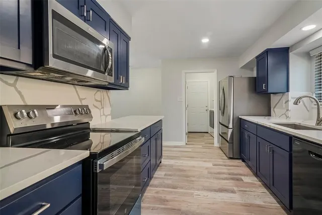 a kitchen with stainless steel appliances a stove microwave and refrigerator