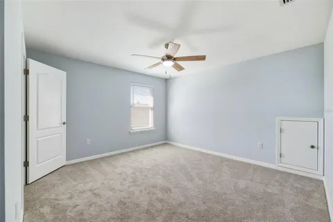 an empty room with a window and ceiling fan