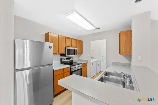 a kitchen with stainless steel appliances a refrigerator and a stove top oven