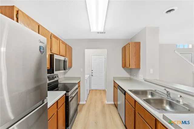 a kitchen with a sink stove and refrigerator