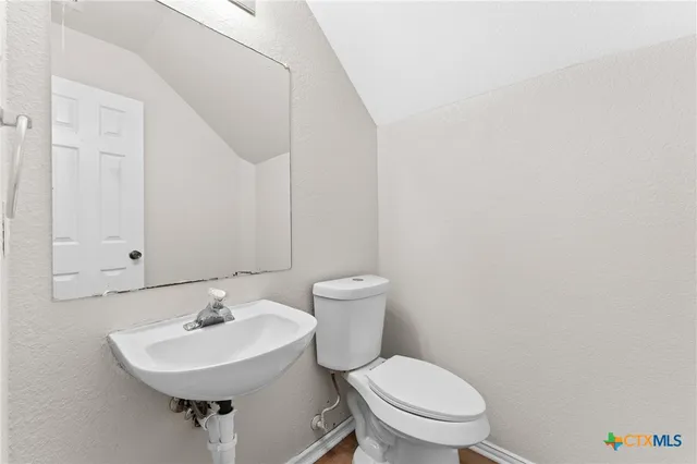 a bathroom with a sink a toilet and mirror