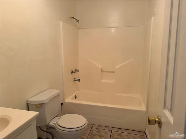 a white toilet and tub sitting next to a bathroom sink