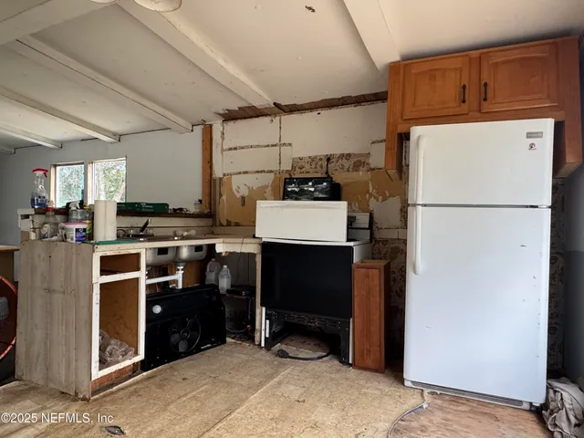 a view of a kitchen with fridge and a sink