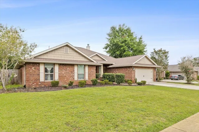 a front view of a house with a garden and yard