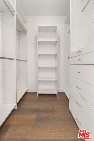 a view of walk in closet with empty racks