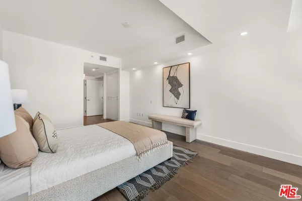 a bedroom with a bed and a painting on the wall