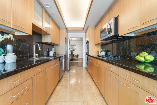 a large kitchen with stainless steel appliances granite countertop a sink and cabinets