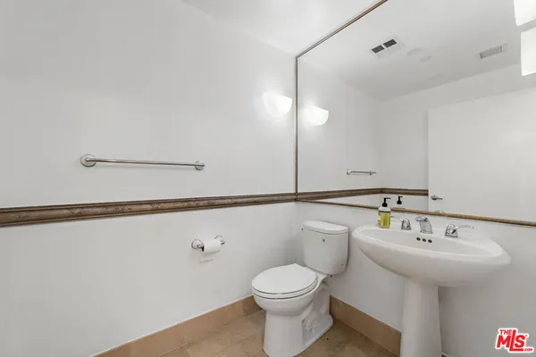 a bathroom with a sink a mirror and toilet