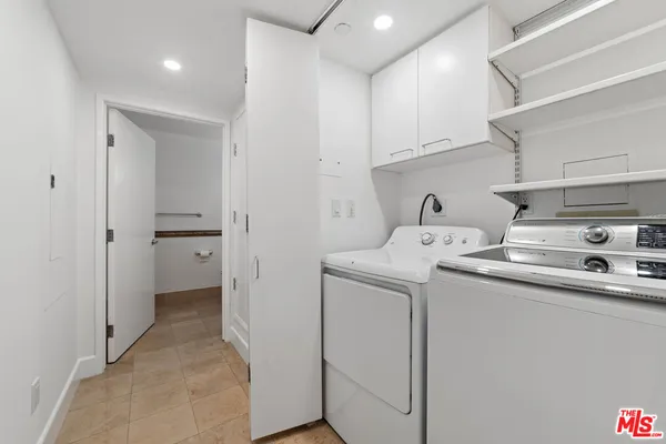 a utility room with cabinets washer and dryer